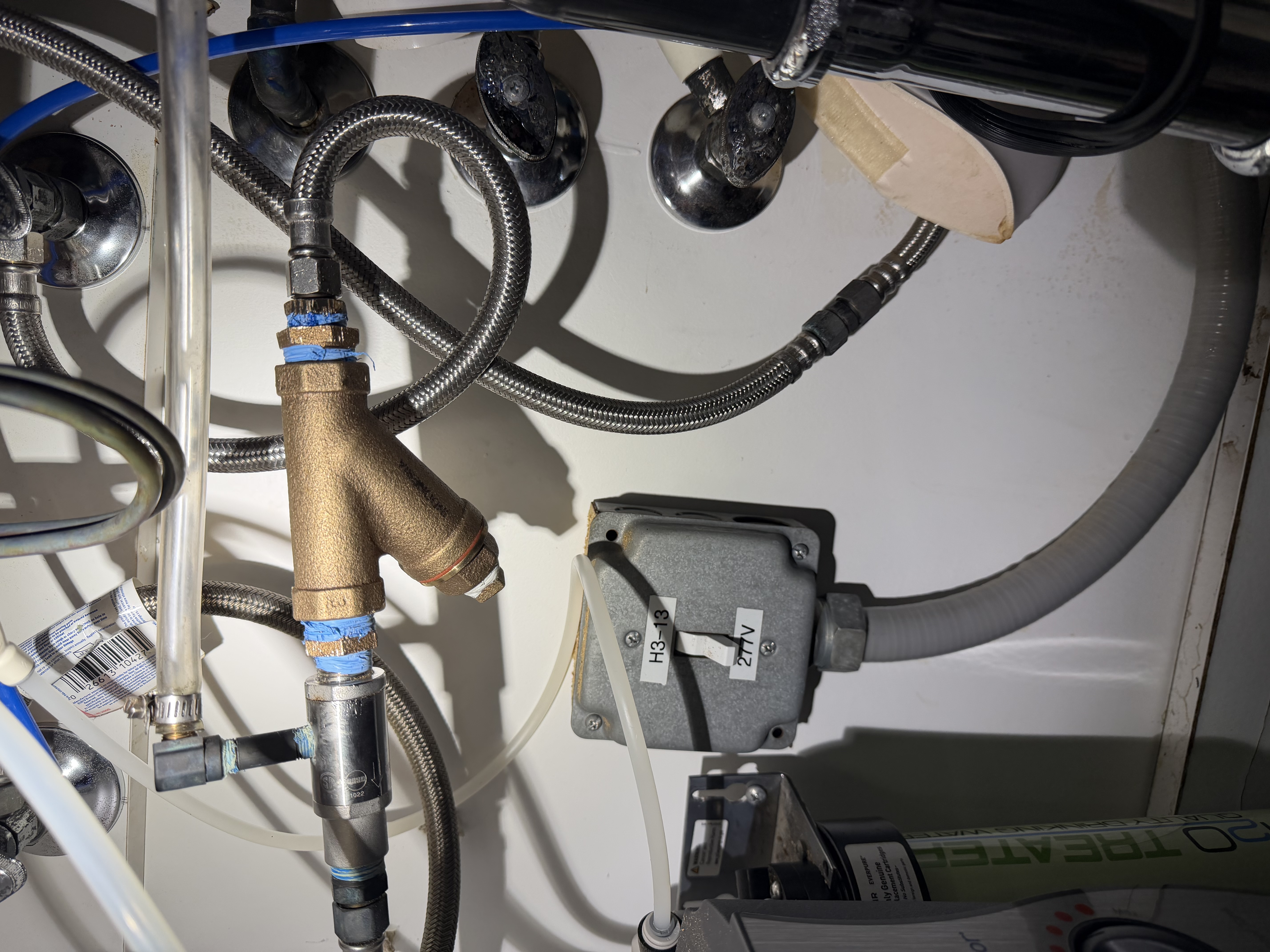 Under-sink plumbing with mixing valve and solenoid in commercial office restroom