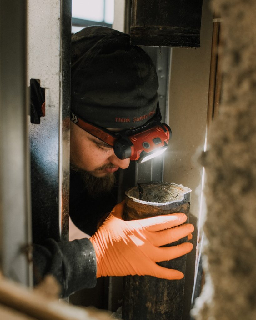 Repairing a corroded cast iron drain pipe to restore proper flow and prevent future leaks