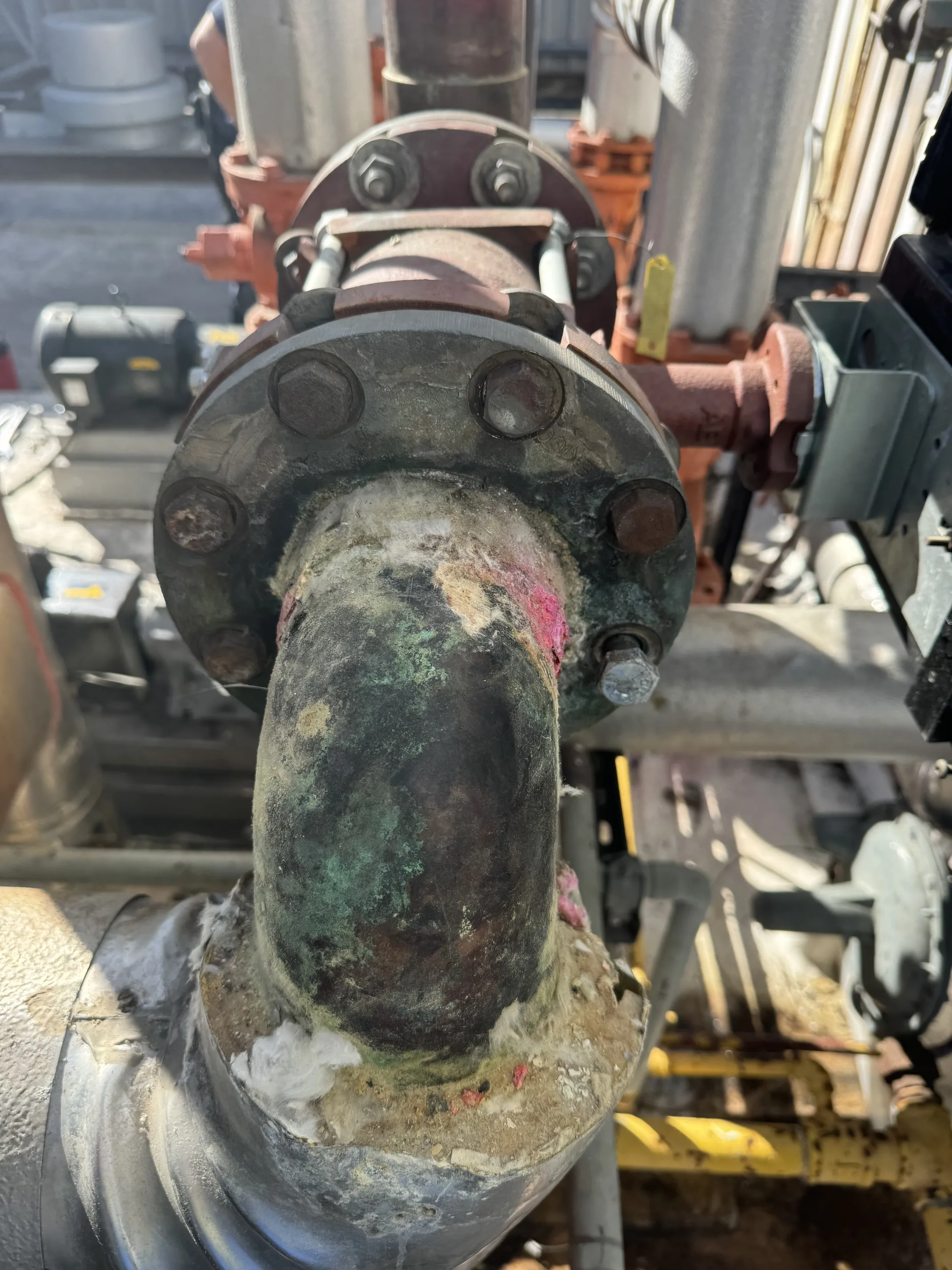 Corroded industrial pipe flange showing decades of mineral buildup