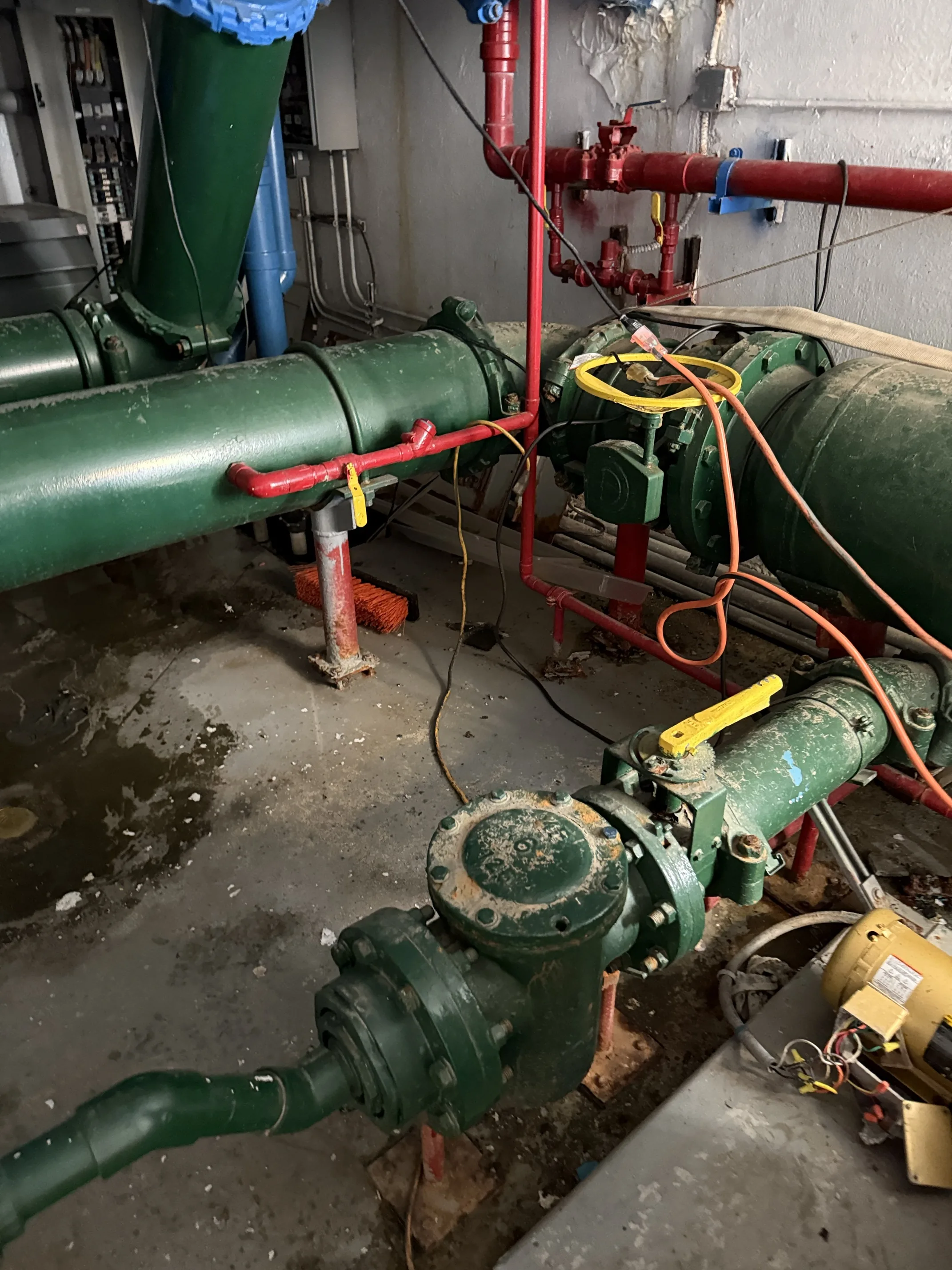 Commercial pump room with green Taco pumps and fire protection piping