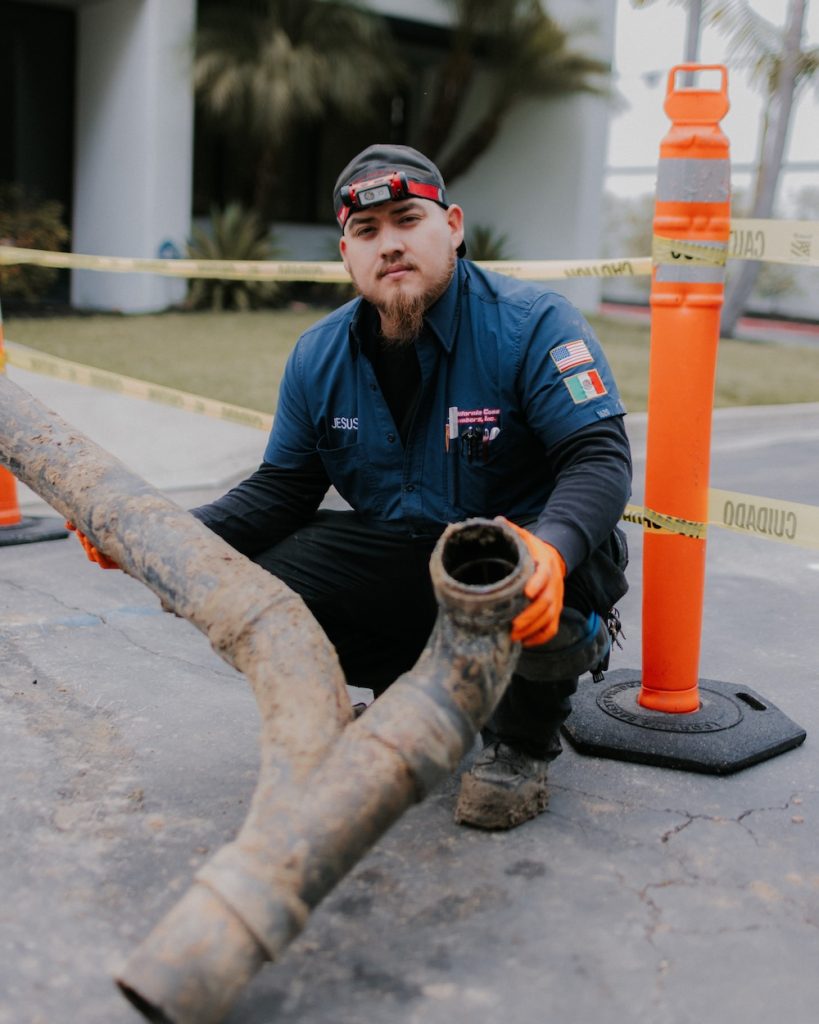 California Coast Plumbers technician replacing a damaged sewer line with a new two-way cleanout fitting