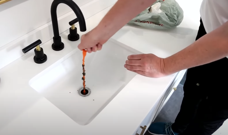 Manually cleaning sink drain