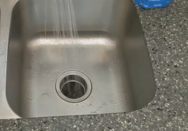 Running hot water through the garbage disposal