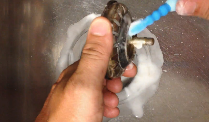 Cleaning sink strainer with a toothbrush 