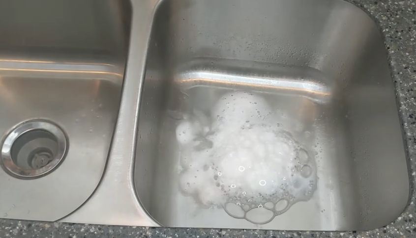 Pouring in baking soda and vinegar in garbage disposal