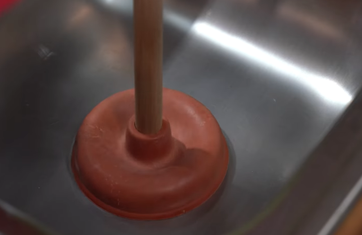 Using a plunger to unclog a sink