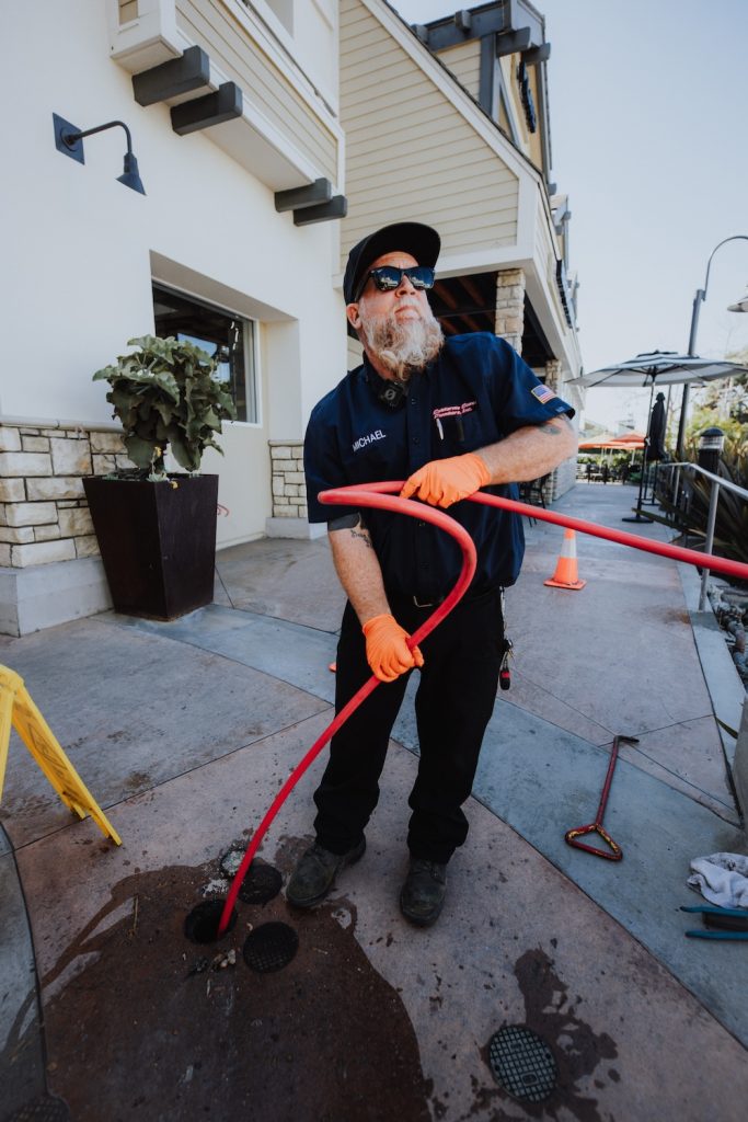 California Coast Plumbers technician setting up for a commercial hydro jetting service